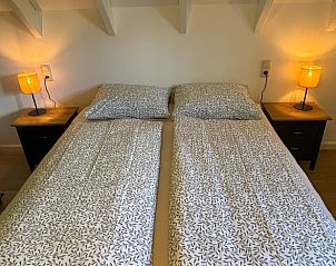 Comfortabel bed in de slaapkamer van Huisje in Aalten, vakantiehuis in Aalten, Achterhoek, met sfeervolle verlichting.