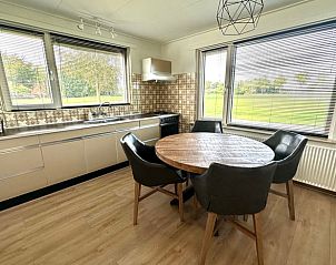 Gezellige keuken in Huisje in Aalten, vakantiehuis in de Achterhoek, Gelderland, met uitzicht op groene omgeving en ruime eethoek.