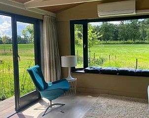 Lichte woonkamer met grote ramen in Huisje in Aalten, Achterhoek, Gelderland.