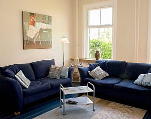 Comfortabele woonkamer in Vakantiehuisje in Laren, Achterhoek, met blauwe banken.