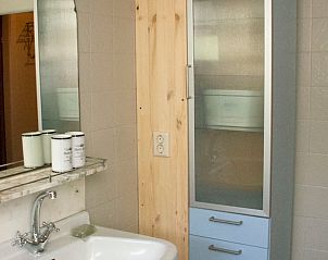 Badkamer met wastafel en spiegel in Vakantiehuisje in Laren, Gelderland.