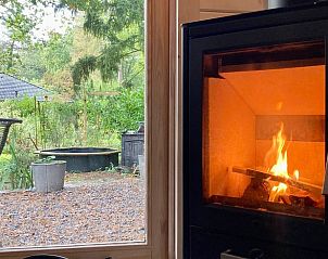 Gezellige open haard in Vakantiehuisje in Lochem, Achterhoek, met uitzicht op de tuin.
