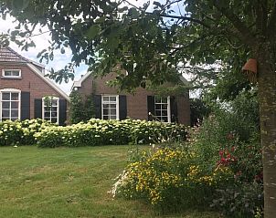 Vakantiehuisje in Lochem, Achterhoek met bloeiende tuin en traditionele architectuur, perfect voor natuurliefhebbers.