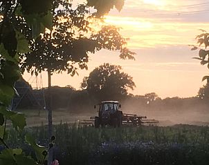 Tractor bij zonsondergang in de buurt van Vakantiehuisje in Lochem, perfect voor een landelijke ervaring.