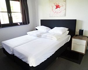 Slaapkamer met tweepersoonsbed in Vakantiehuis De Wiersse 6, Lochem, Achterhoek, Gelderland, met bloemdecor.