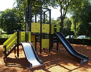 Kleurrijke speeltuin bij Vakantiehuis Bronckhorst 6, Lochem, Achterhoek, Gelderland, omgeven door bomen.