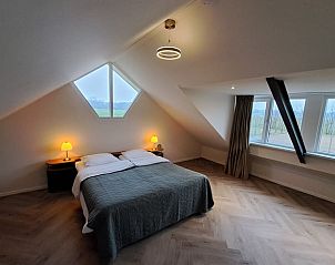 Sfeervolle slaapkamer in Vakantiehuisje in Lochem met uitzicht op de Achterhoekse velden, Gelderland.