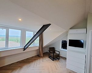 Gezellige zithoek in Vakantiehuisje in Lochem met uitzicht op de groene omgeving van de Achterhoek, Gelderland.