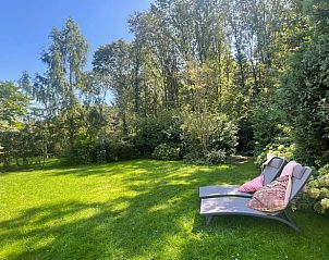 Groene tuin van Vakantiehuis in Lochem met ligstoelen voor ontspanning in de Achterhoek, Gelderland.