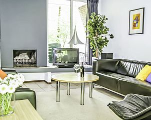 Moderne woonkamer in Vakantiehuis 4L, Lochem met comfortabele banken en open haard voor gezellige avonden in de Achterhoek.