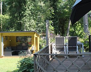 Terras met zitplek en parasol bij Vakantiehuisje in Lochem, Gelderland.