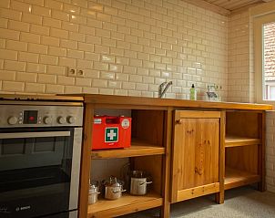 Modern kitchen in Holiday Home in Lochem, Achterhoek, Gelderland with wooden countertop and tiled wall for a comfortable stay.