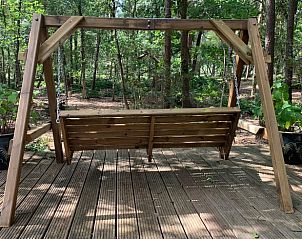 Houten schommelbank op het terras van Vakantiehuis in Harfsen, Achterhoek, voor ontspanning.