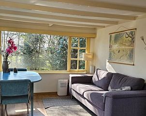 Gemtliches Wohnzimmer des Ferienhauses in Harfsen, Achterhoek, Gelderland mit Blick in die Natur und bequemer Sitzecke.