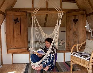 Lezen in hangstoel bij Huisje in Haarlo, vakantieverblijf in Achterhoek, Gelderland.