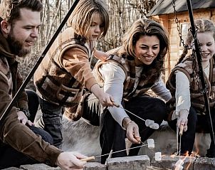 Familie roostert marshmallows bij Vakantiehuis in Haarlo, Achterhoek, Gelderland voor een knisperend kampvuur.