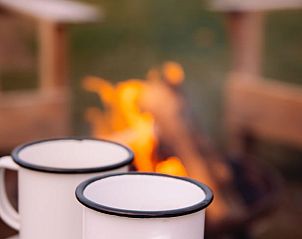 Warme drankjes bij het kampvuur in Vakantiehuis in Haarlo, Achterhoek, Gelderland voor een knusse avond.