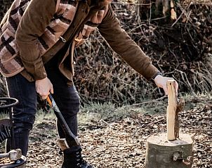 Hout hakken voor het kampvuur bij Vakantiehuis in Haarlo, Achterhoek, Gelderland voor een authentieke ervaring.
