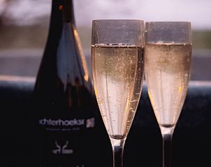 Bubbels en wijn bij zonsondergang in Vakantiehuisje in Haarlo, Achterhoek, Gelderland voor een romantisch moment.