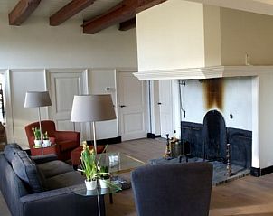 Gezellige woonkamer van Erve Lieftink_Boerderij de Esch in Geesteren, Achterhoek met open haard en comfortabele zithoek.