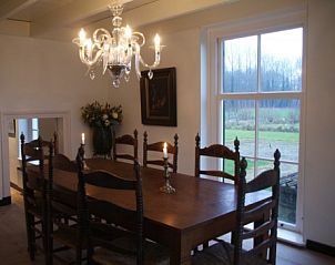 Elegante eetkamer met kroonluchter in Erve Lieftink_Boerderij de Esch, Geesteren, Achterhoek, uitkijkend op de landelijke omgeving.