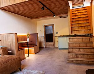 Gezellige binnenruimte van Vakantiehuisje in Neede, Achterhoek, met houten interieur en comfortabele zithoek.