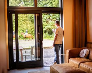 Uitzicht vanuit de woonkamer van Vakantiehuisje in Neede, Achterhoek, met zicht op de groene omgeving.