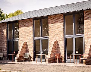 Buitenzijde van Vakantiehuisje in Neede, Achterhoek, met uitnodigende terrassen voor ontspanning.