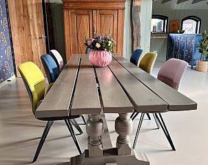 Stijlvolle eetkamer in Huisje in Neede, vakantiehuis in de Achterhoek, Gelderland, met kleurrijke stoelen.