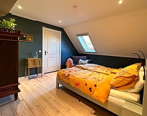 Sfeervolle slaapkamer in Huisje in Neede, vakantiehuis in de Achterhoek, Gelderland, met kleurrijk beddengoed.