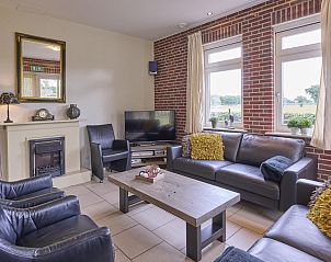 Gezellige woonkamer van vakantiehuis t Achterhoes in Neede, Achterhoek, met comfortabele zithoek en uitzicht op het groene landschap.