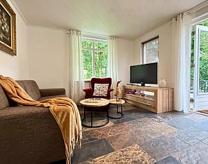 Lichte woonkamer met uitzicht op de tuin in Vakantiehuisje in Neede