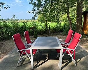 Terras met tuinstoelen in Vakantiehuisje in Neede, een plek om te genieten van de Achterhoekse natuur.
