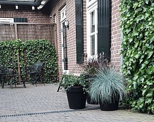 Cozy porch at Holiday home in Varsselder, located in the Achterhoek region of Gelderland, with atmospheric lighting and a hanging chair.