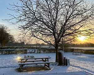 Winterse tuin met picknicktafel bij Vakantiehuisje in Breedenbroek, Achterhoek, Gelderland.