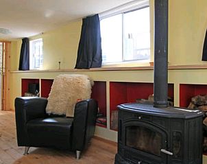 Vakantiehuis in Almen, gezellige stoel bij de open haard in de Achterhoek, Gelderland.