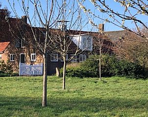 Huisje in Almen, vakantieaccommodatie in de Achterhoek, Gelderland. Rustieke uitstraling met bloeiende bomen in de groene omgeving.