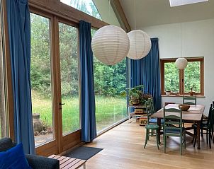 Gezellige eetruimte in Vakantiehuis in Almen met houten vloer en uitzicht op de tuin in Achterhoek, Gelderland.