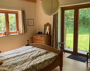 Slaapkamer in Vakantiehuis in Almen met houten meubels en toegang tot de tuin, gelegen in Achterhoek, Gelderland.