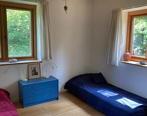 Slaapkamer met twee bedden in Vakantiehuis in Almen, met uitzicht op de tuin in Achterhoek, Gelderland.