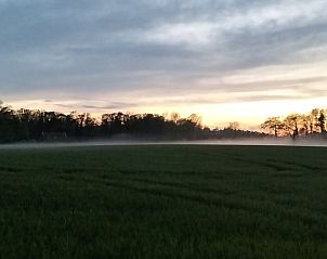 Rustige zonsondergang bij Vakantiehuisje in Winterswijk Woold, omgeven door velden in de Achterhoek, Gelderland.