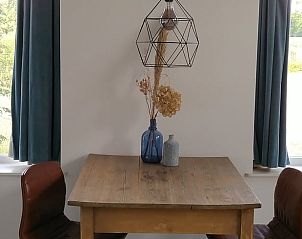 Gezellige eethoek met decoratieve vaas in Vakantiehuis in Winterswijk Woold, perfect voor intieme maaltijden in de Achterhoek, Gelderland.