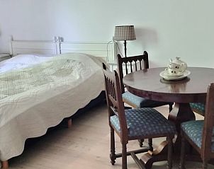 Gezellige slaapkamer in Vakantiehuisje in Winterswijk Woold met houten meubels in Achterhoek, Gelderland.