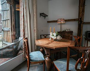 Gezellige eethoek in Huisje in Winterswijk Woold, vakantiehuis in de Achterhoek, met uitzicht op de binnenplaats.