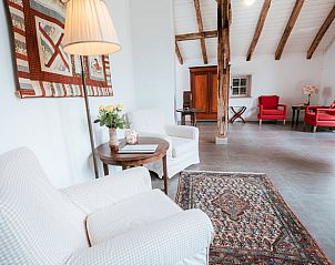 Comfortabele zithoek in Huisje in Winterswijk Woold, vakantiehuis in de Achterhoek, met rustieke details.