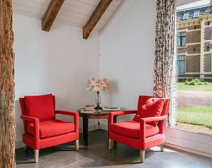 Knusse leeshoek in Huisje in Winterswijk Woold, vakantiehuis in de Achterhoek, met uitzicht op de tuin.