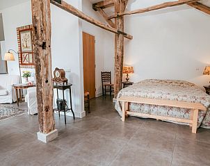 Ruime slaapkamer in Huisje in Winterswijk Woold, vakantiehuis in de Achterhoek, met rustieke balken.