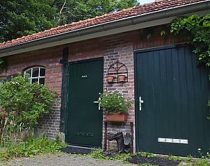 Buitenaanzicht van bijgebouw Vakantiehuis in Winterswijk Woold met groene accenten in Achterhoek, Gelderland.