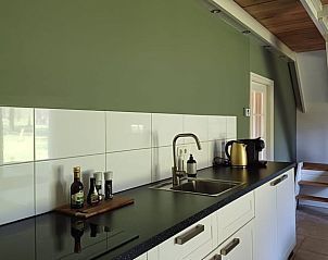 Keuken met groene muur in vakantiehuis in Winterswijk Woold, stijlvol en functioneel in Gelderland.