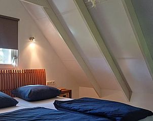 Gezellige slaapkamer met schuine wanden in vakantiehuis in Winterswijk Woold, ontspannen in de Achterhoek.